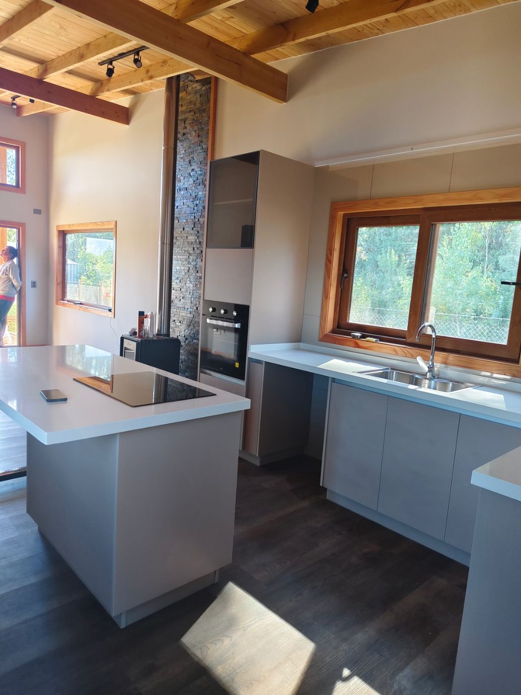 Cocina de cabaña con isla y vigas de madera a la vista