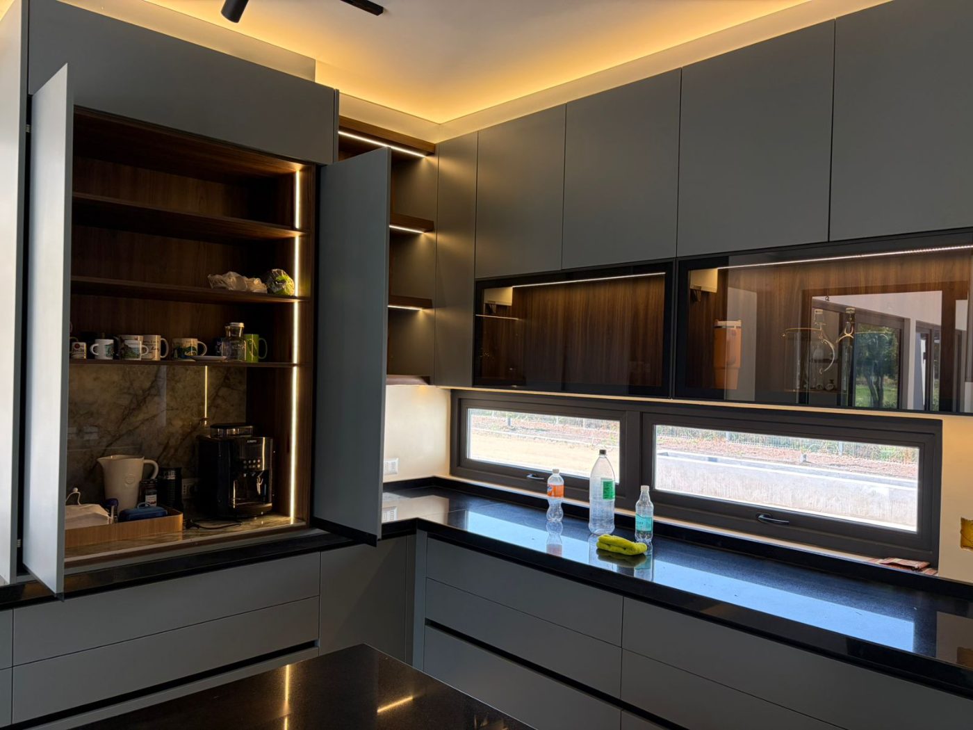 Estación de café oculta con iluminación interior en cocina a medida